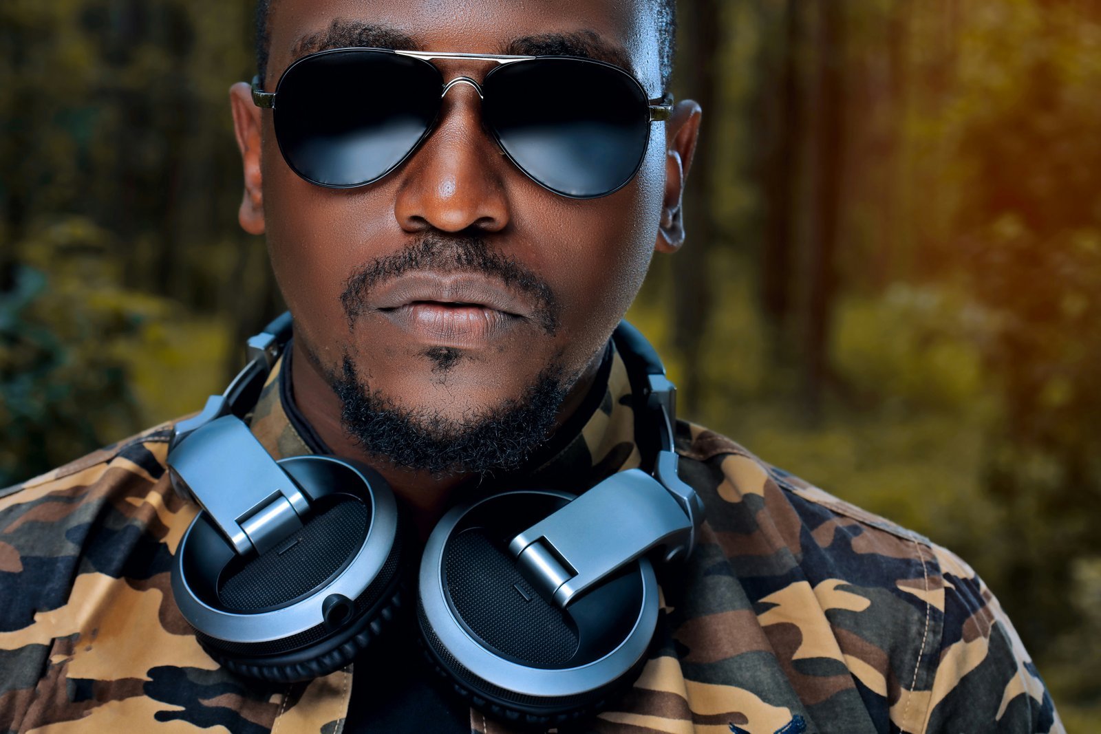 man wearing sunglasses and grey and black headphones