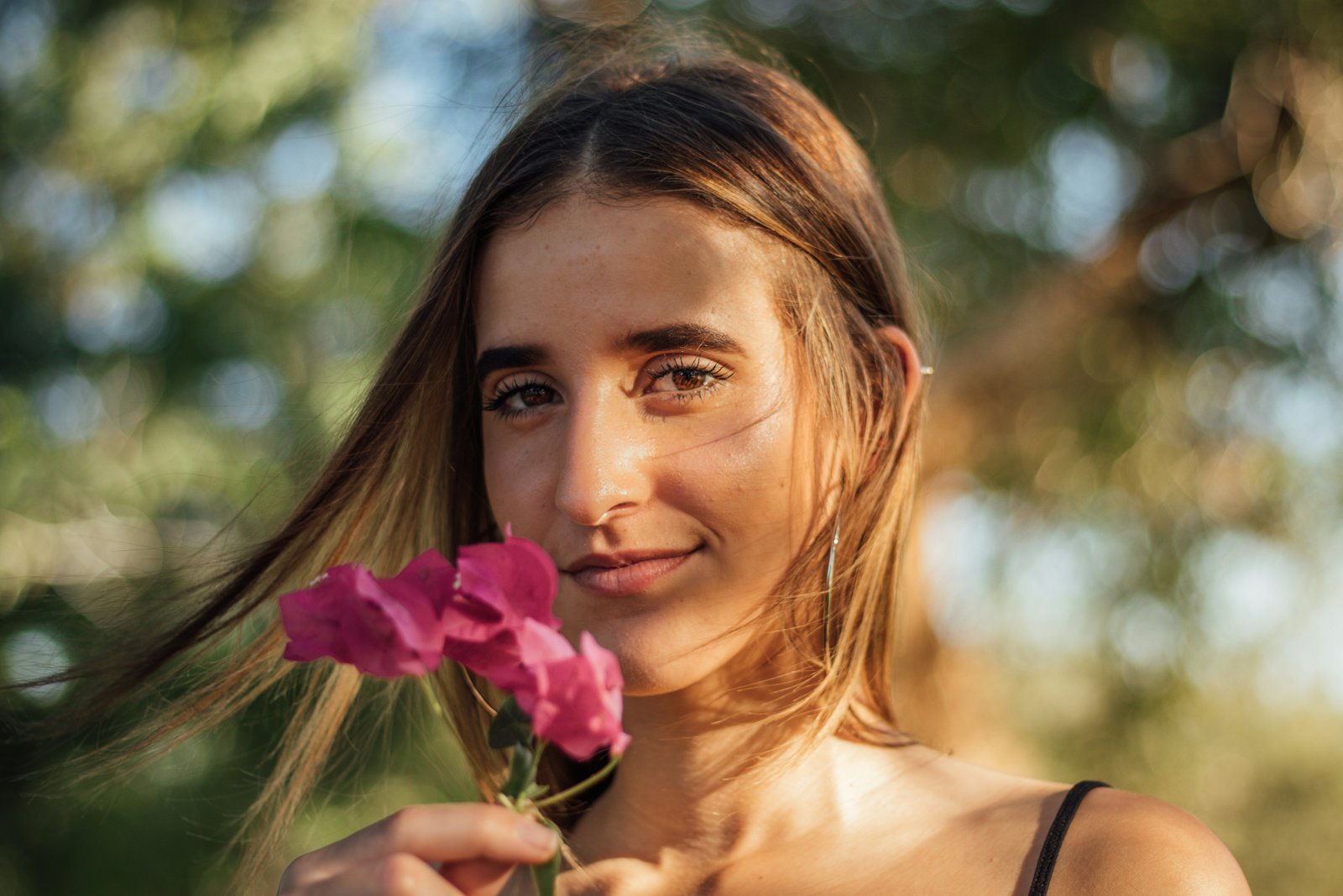 woman holding pink flowers